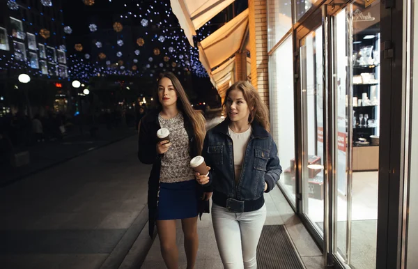 Due ragazze alla moda che camminano in viale di città di notte — Foto Stock