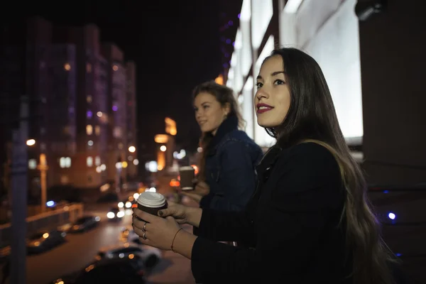 Dwóch przyjaciół młoda kobieta, patrząc na ulicy miasta z balkonem w nocy — Zdjęcie stockowe