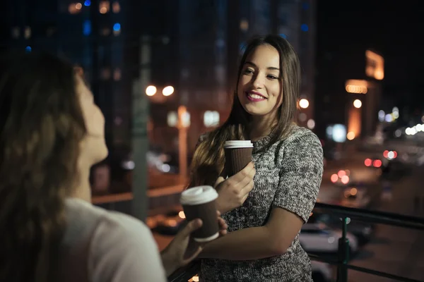 Twee jonge vrouw vrienden spreken in balkon bij nacht — Stockfoto