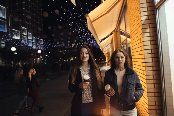 Due ragazze alla moda che camminano in viale di città di notte — Foto Stock