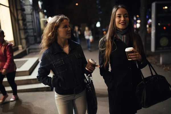Dos novias a la moda caminando por la avenida de la ciudad por la noche — Foto de Stock