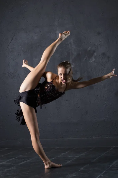 Jonge professioneel danser maken een bindgaren tegen getextureerde muur achtergrond — Stockfoto