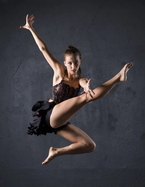 Молодий професійний танцюрист стрибає на тлі текстурованих стін — стокове фото