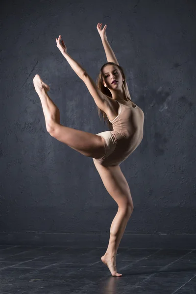 Professional woman dancer posing at wall