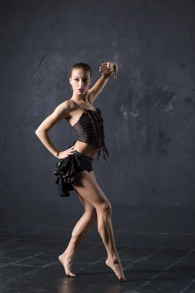 Elegante vrouw dans in donkere studio — Stockfoto