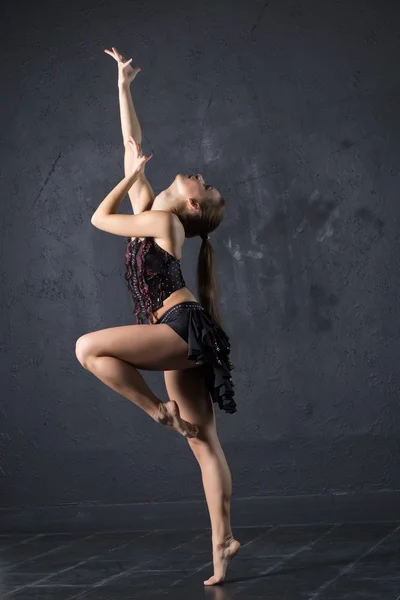 Елегантна жінка танцює в темній студії — стокове фото