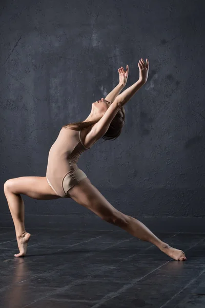 Elegante vrouw dans in donkere studio — Stockfoto