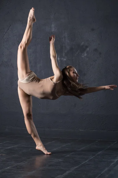 Linda chica bailando sobre fondo de pared texturizado gris — Foto de Stock
