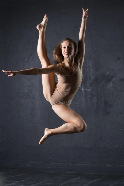 Linda chica bailando sobre fondo de pared texturizado gris — Foto de Stock