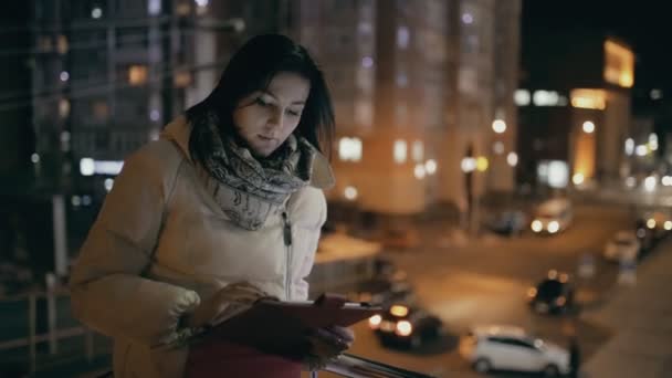 Vrouw met behulp van smartphone in een nacht stad — Stockvideo