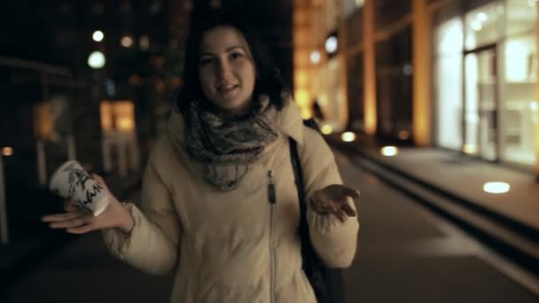 Mujer caminando en la ciudad por la noche y hablando en cámara — Vídeo de stock