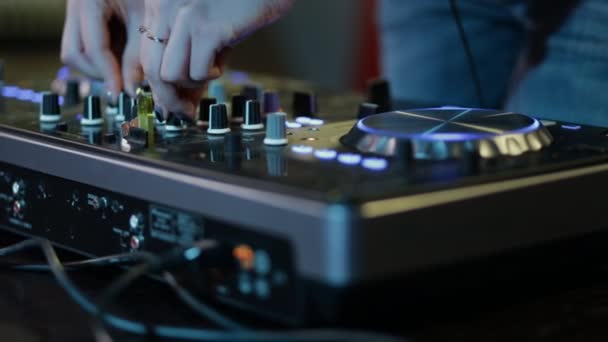 Mãos femininas de DJ ajustam controles de faixa no deck do dj, câmera está respirando — Vídeo de Stock