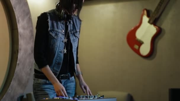 Femme DJ modifier différents contrôles de piste sur le pont de DJ à la boîte de nuit — Video