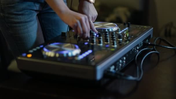 Mãos femininas de DJ ajustam controles de pista no deck do dj — Vídeo de Stock