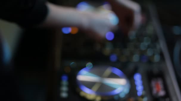 Las manos femeninas de DJ ajustan los controles de pista en la cubierta de DJ, enfoque borroso — Vídeo de stock