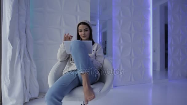 Femme drôle tournant sur une chaise confortable et écouter de la musique — Video