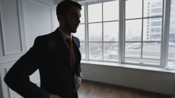 Geschäftsmann in weißem Büro wartet und denkt beim Blick aufs Fenster — Stockvideo