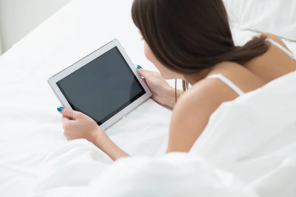 Mulher deitada na cama com seu tablet PC e internet surf — Fotografia de Stock