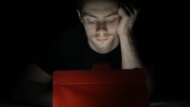 Человек, использующий цифровой планшет в темноте — стоковое видео