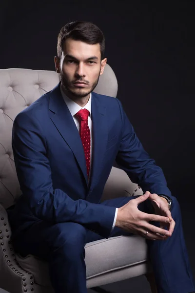Портрет білоруського бізнесмена, що сидить на кріслі, чорний фон — стокове фото