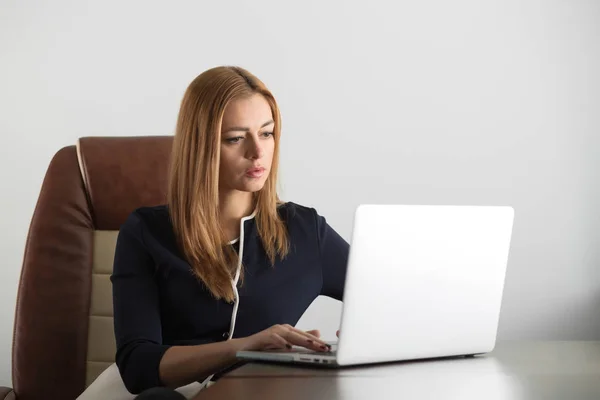 Attraktive erwachsene Frau sitzt an ihrem Arbeitsplatz im Büro — Stockfoto