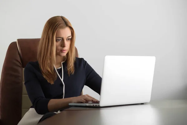 Attraente donna adulta seduta alla sua postazione di lavoro in ufficio — Foto Stock