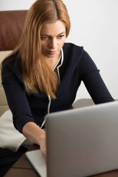 女人坐在她办公室里的工作站和笔记本电脑的工作 — 图库照片