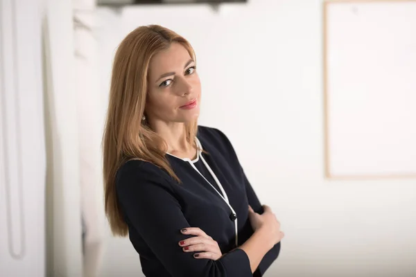 Adult caucasian businesswoman looking confidently at camera in workplace — Stock Photo, Image
