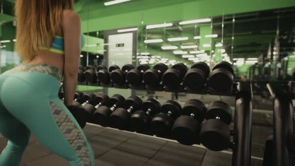 Vrouw in de gym squat met halters — Stockvideo