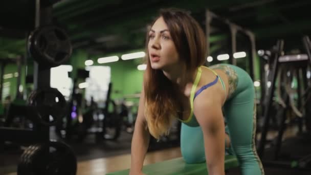 Сильная женщина делает упражнения в спортзале. Она поднимает гантель . — стоковое видео