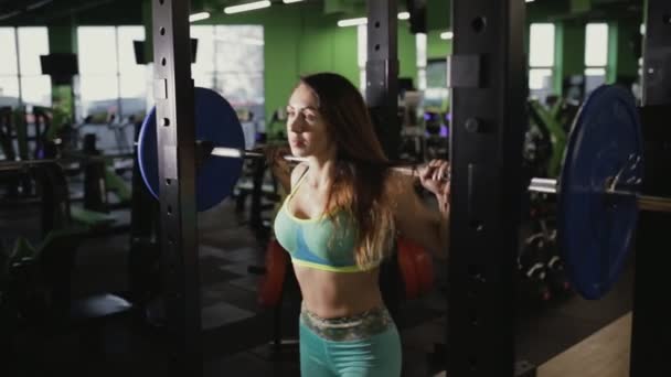 Starke Frau macht Kniebeuge im Fitnessstudio. sie hebt die Langhantel. — Stockvideo