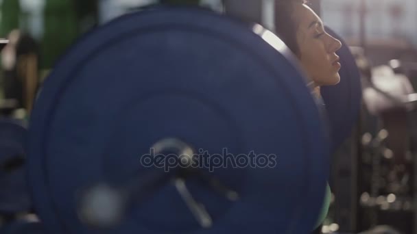 Starke Frau macht Kniebeuge im Fitnessstudio. sie hebt die Langhantel. — Stockvideo