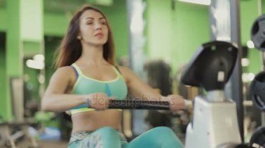 Kadın olun kürek makine spor salonunda egzersiz