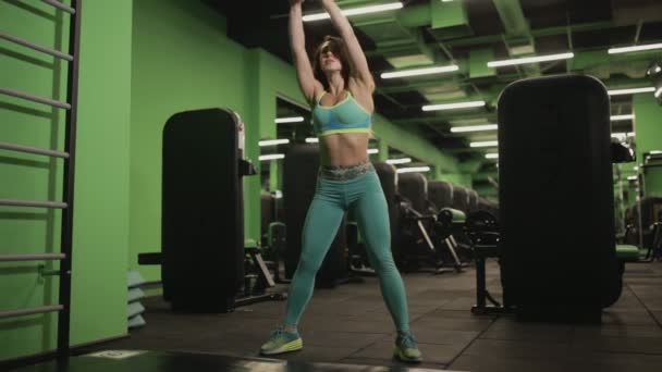 Frau macht Übung mit Gewicht im Fitnessstudio — Stockvideo