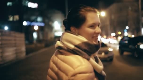 Молода приваблива жінка робить повітряний поцілунок в нічному місті — стокове відео