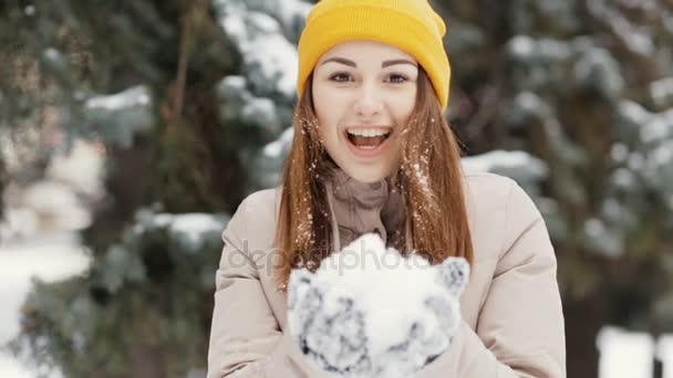 Přišla zima. Šťastná mladá žena vyvolá sníh ve vzduchu, pomalý pohyb. — Stock video