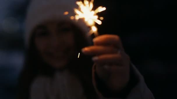 Mulher no inverno desfrutando com um sparkler ao ar livre em uma praça urbana — Vídeo de Stock