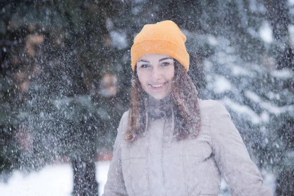 Gelukkig jonge vrouw onder sneeuwval op de winterdag — Stockfoto