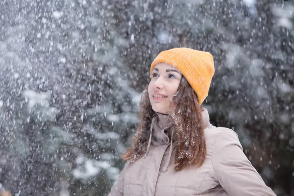 Feliz joven bajo las nevadas en el día de invierno —  Fotos de Stock