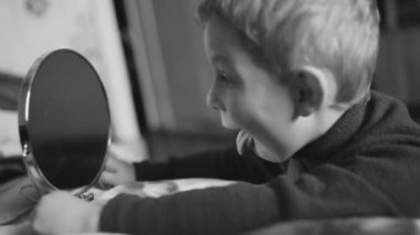 Ev Oda aynada ile oynayan çocuk. Dil gösteriliyor. Tek renkli.