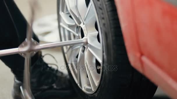 Carro mecânico desaparafusar roda de carro de automóvel levantado por chave — Vídeo de Stock