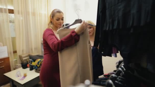 Продавец помогает клиенту в выборе одежды для покупок — стоковое видео