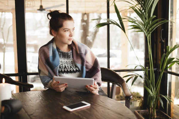 Mujer usando tableta PC y teléfono inteligente en un café, ella mirando a la ventana —  Fotos de Stock