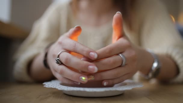 Vrouw opwarming van de aarde handen boven candle - bijgesneden schot — Stockvideo