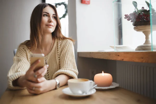 Mujer linda usando su teléfono inteligente en una cafetería — Foto de Stock