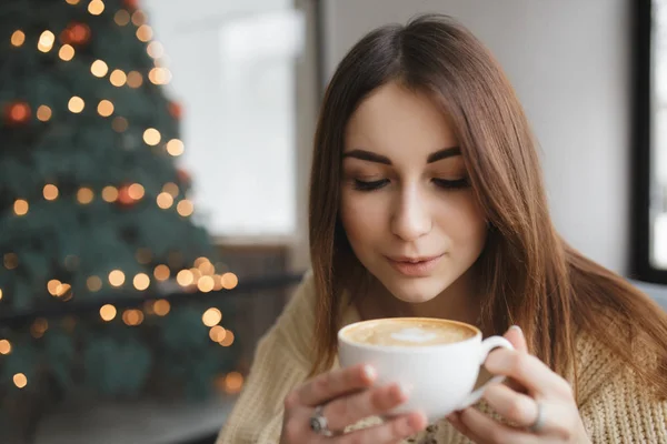 Прекрасная женщина, дующая на чашку кофе в кафе — стоковое фото
