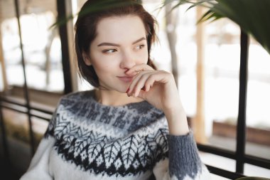 Masada oturan ve bir kafede pencere bakarak kazak kadında