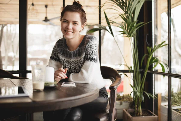 Donna moderna con tablet pc e smartphone in un caffè sorridente alla fotocamera — Foto Stock
