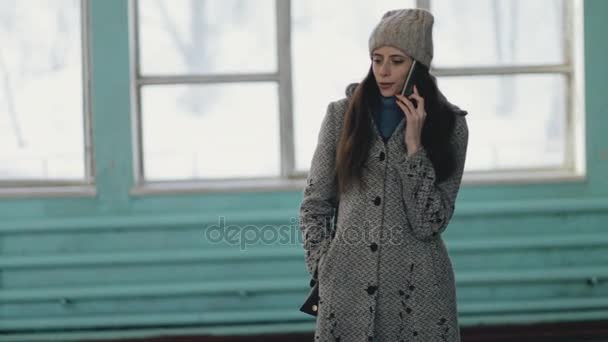 Женщина разговаривает по телефону в старом общественном месте — стоковое видео