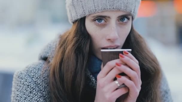Ung kvinna dricker varmt te i vinterkväll — Stockvideo